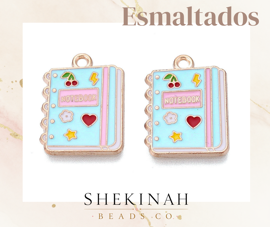 Dije esmaltado con diseño de cuaderno escolar color pastel.