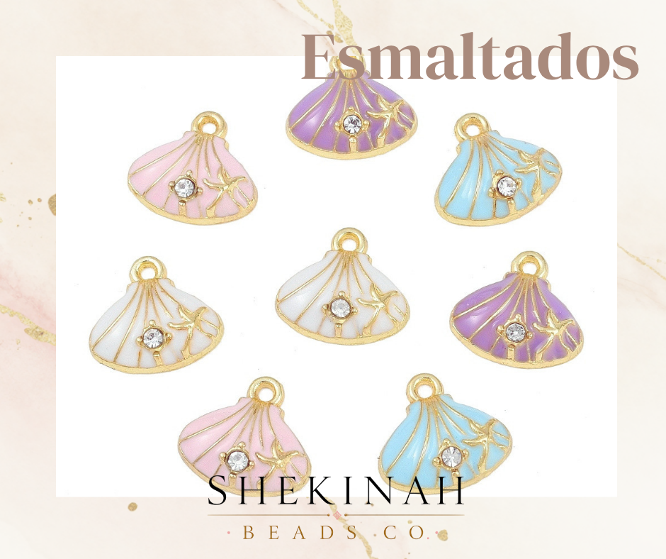 Colorful shell-shaped charms with gold accents on a light background, featuring the brand 'SHEKINAH BEADS CO'.