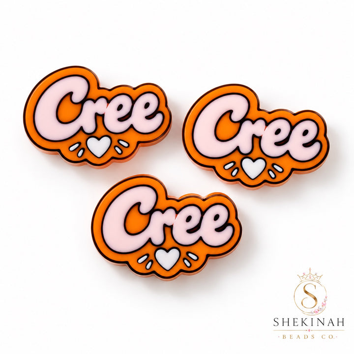 Dije 3D naranja con palabra Cree y corazón