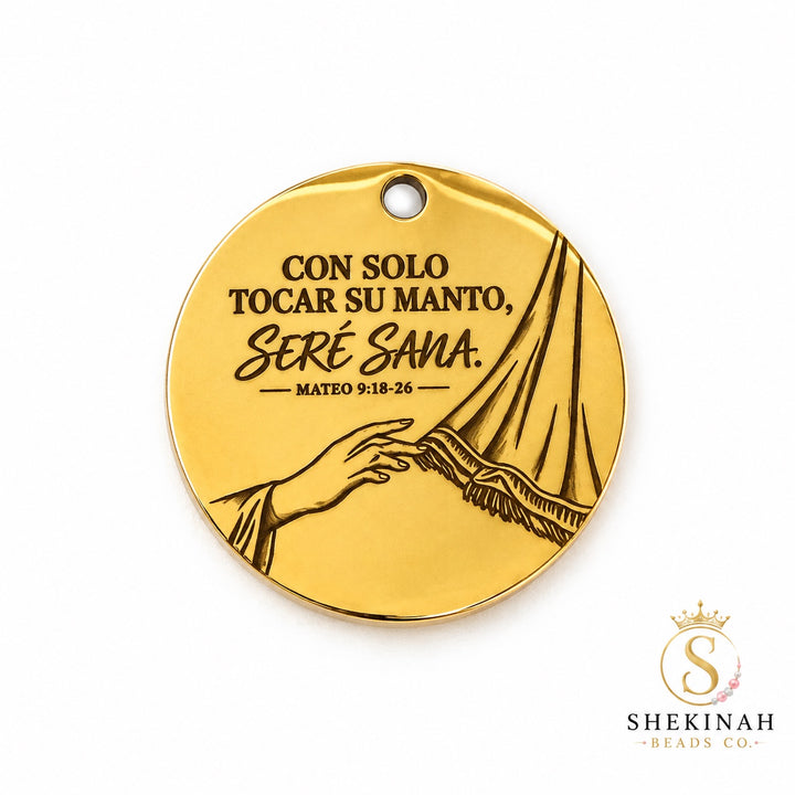 Dije redondo dorado de stainless steel con mensaje Con solo tocar su manto seré sana, Mateo 9:18-26