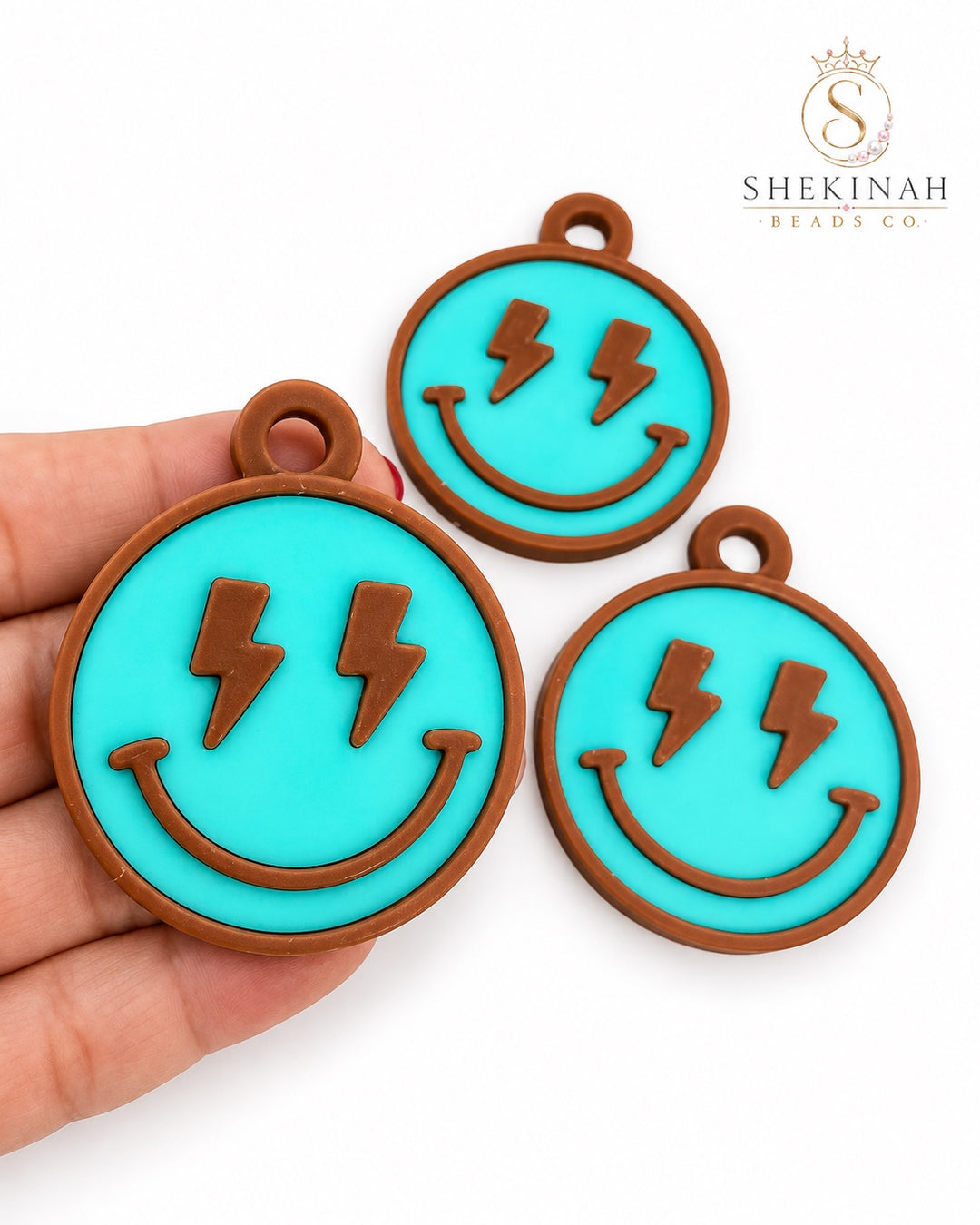 Charm 3D smiley con rayos marrón con azul