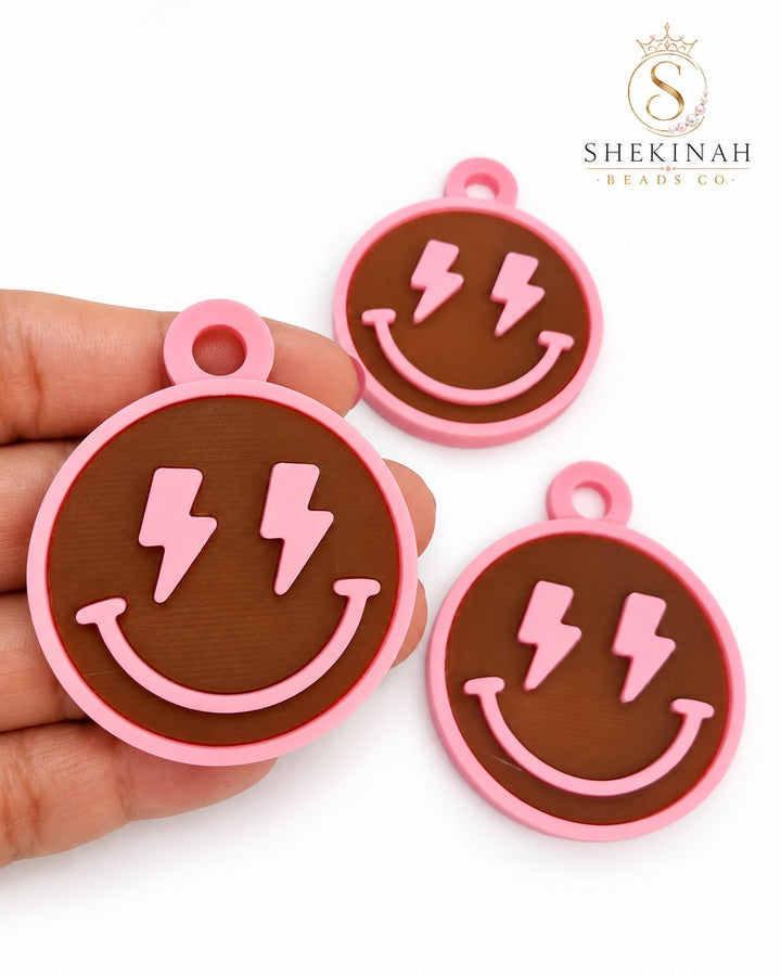 Charm 3D smiley con rayos rosa